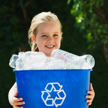 A little child holding a recycling bin