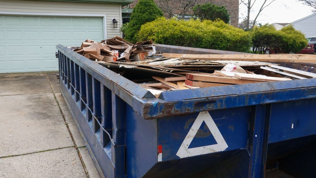 a blue dumpster full of wood
